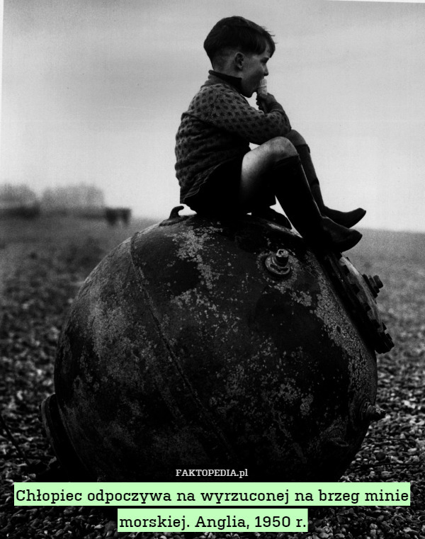 Chłopiec odpoczywa na wyrzuconej na brzeg minie morskiej. Anglia, 1950 r. 